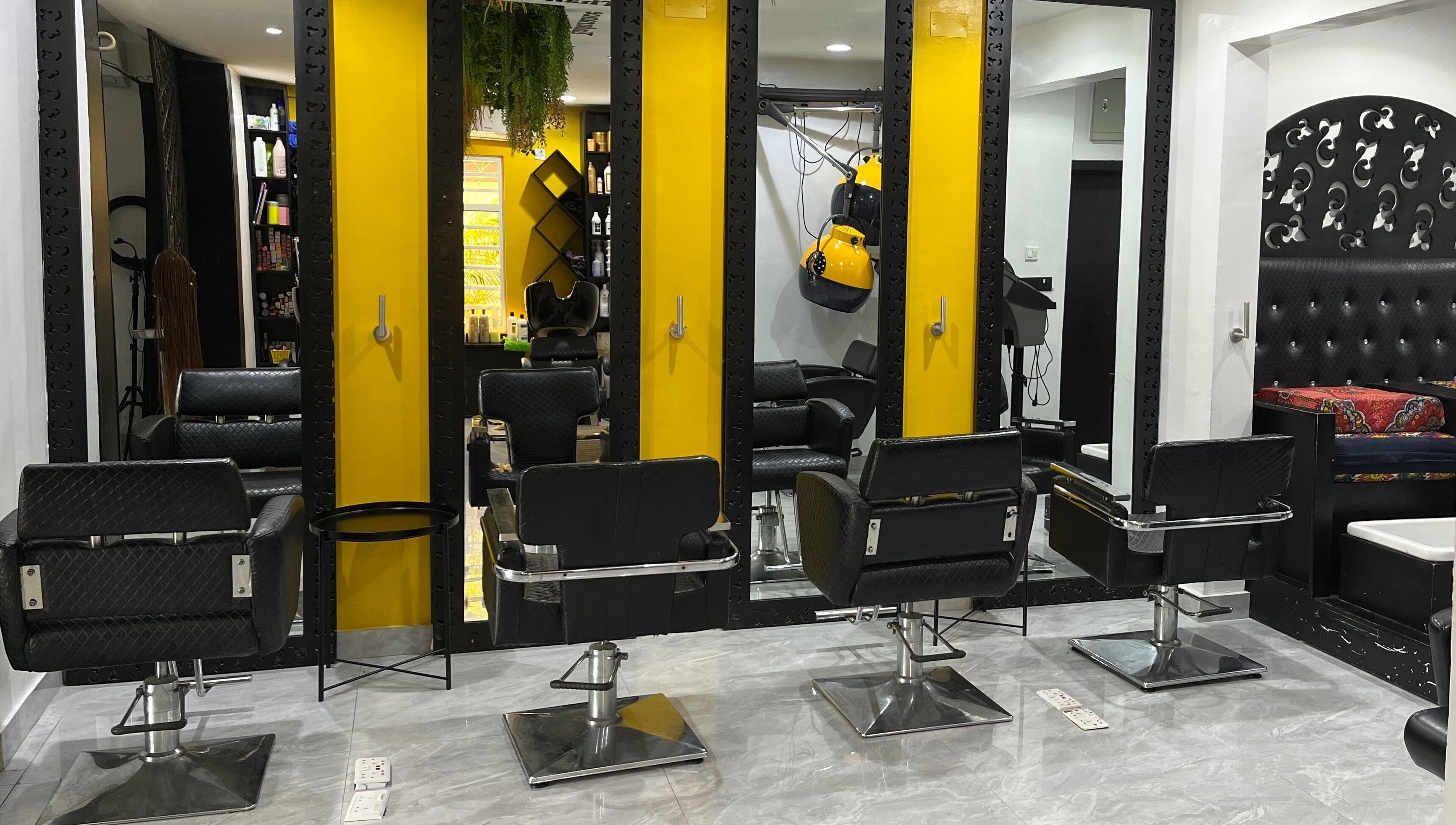Modern salon chairs at Studio M in Lagos, Lagos, NG, with sleek mirrors and vibrant yellow accents.