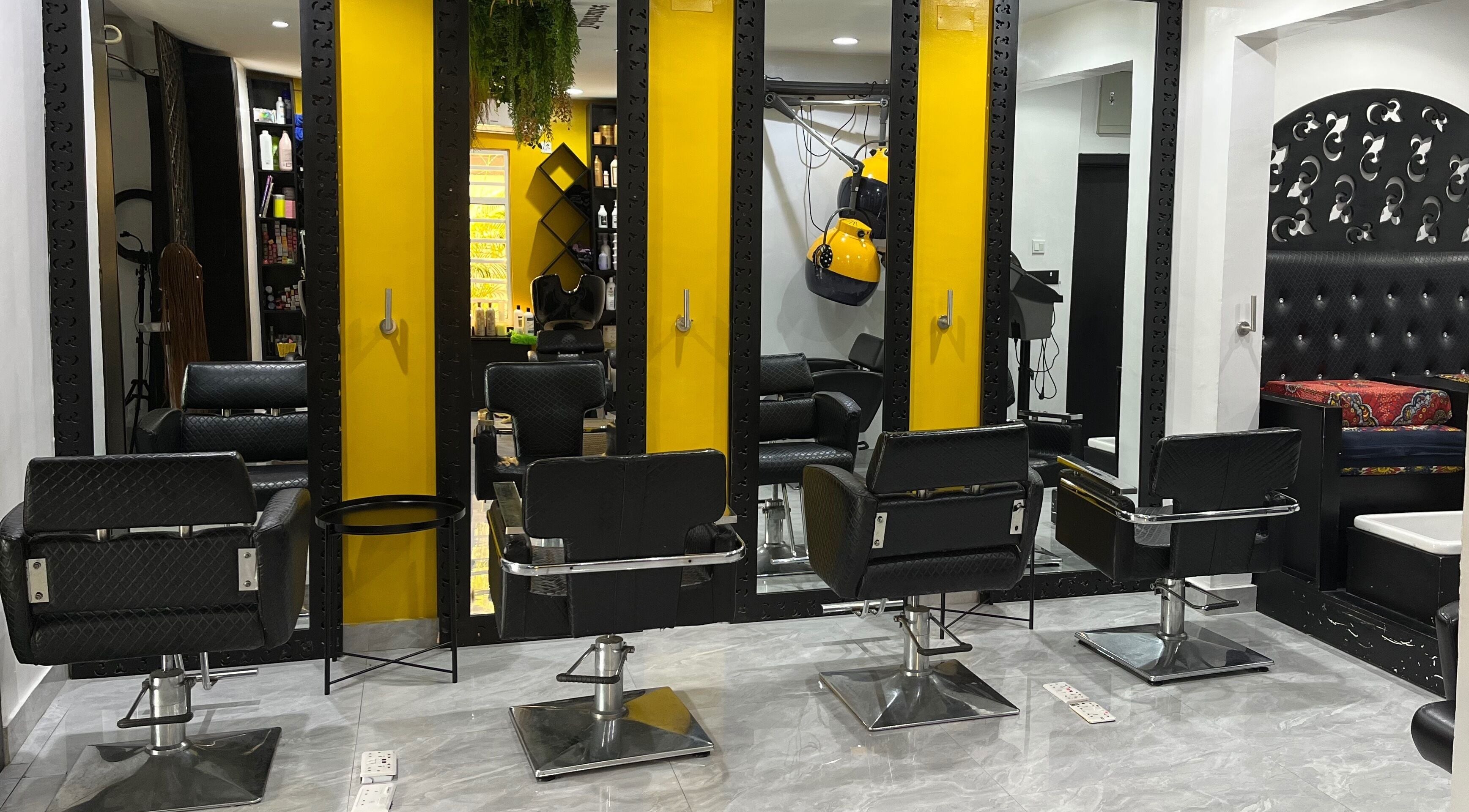 Modern salon chairs at Studio M in Lagos, Lagos, NG, with sleek mirrors and vibrant yellow accents.