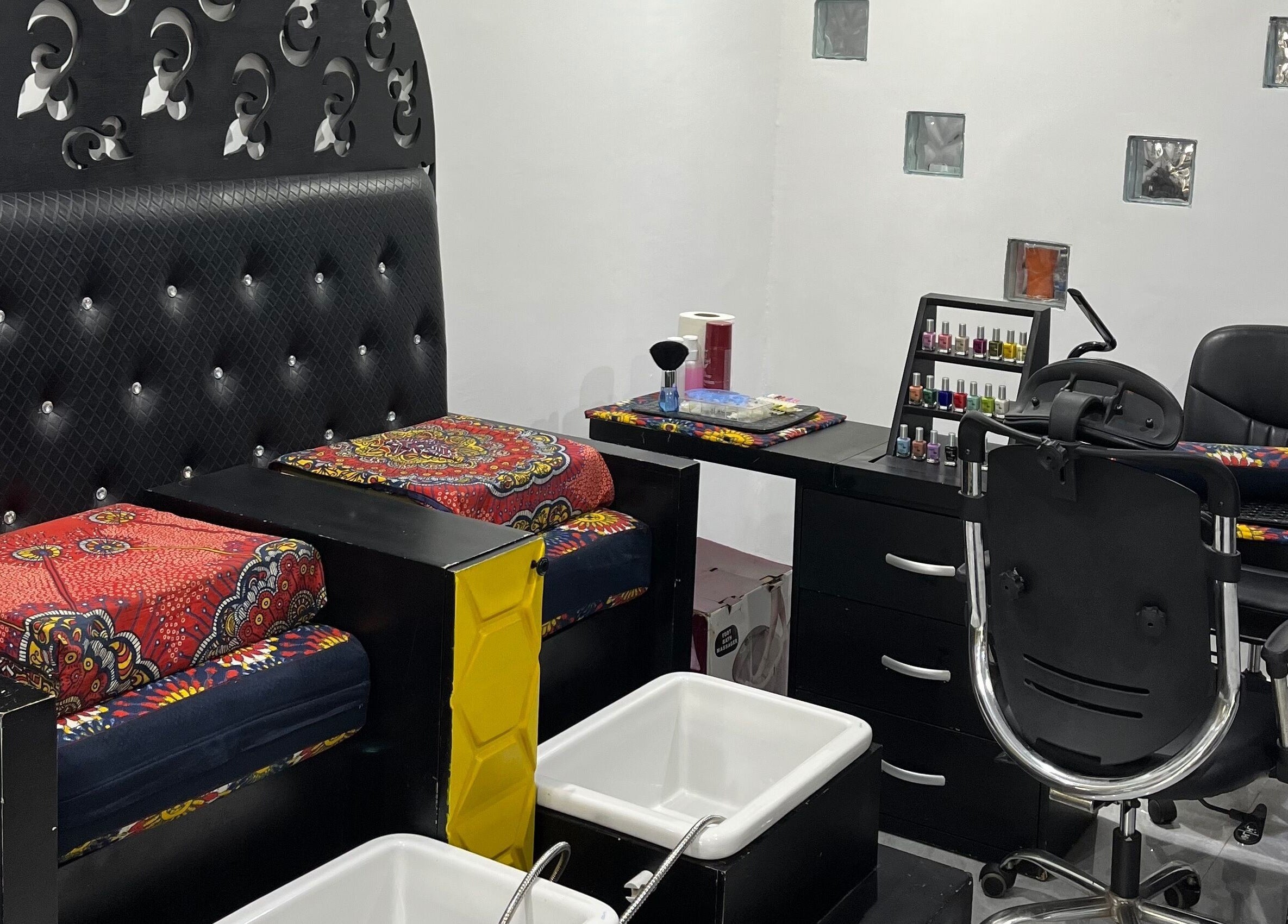 Manicure and pedicure setup at Studio M, Lagos, Lagos, NG. Elegant black and red decor enhances relaxation.
