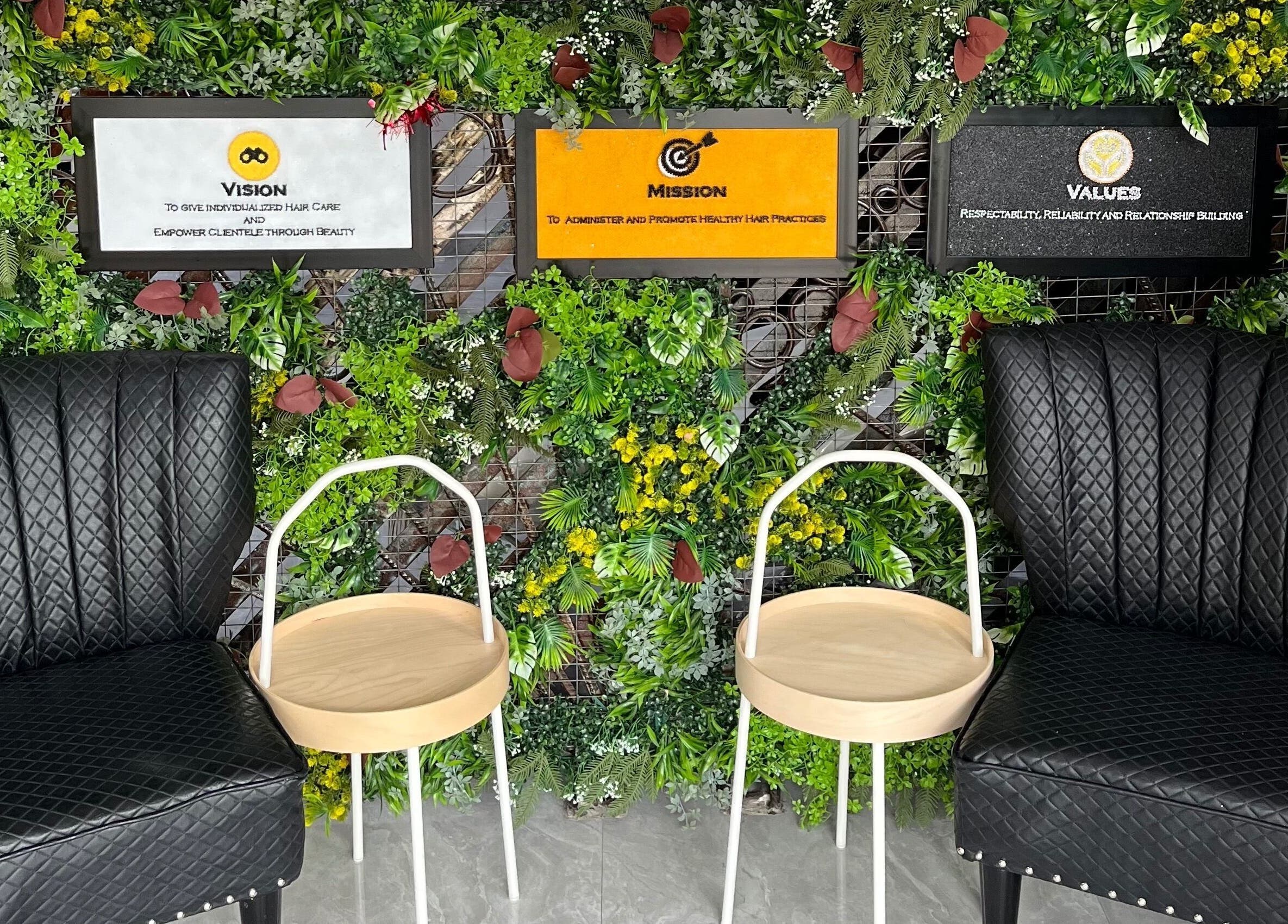 Stylish seating at Studio M, Lagos, Lagos, NG with black chairs, wooden tables, set against lush green decor.