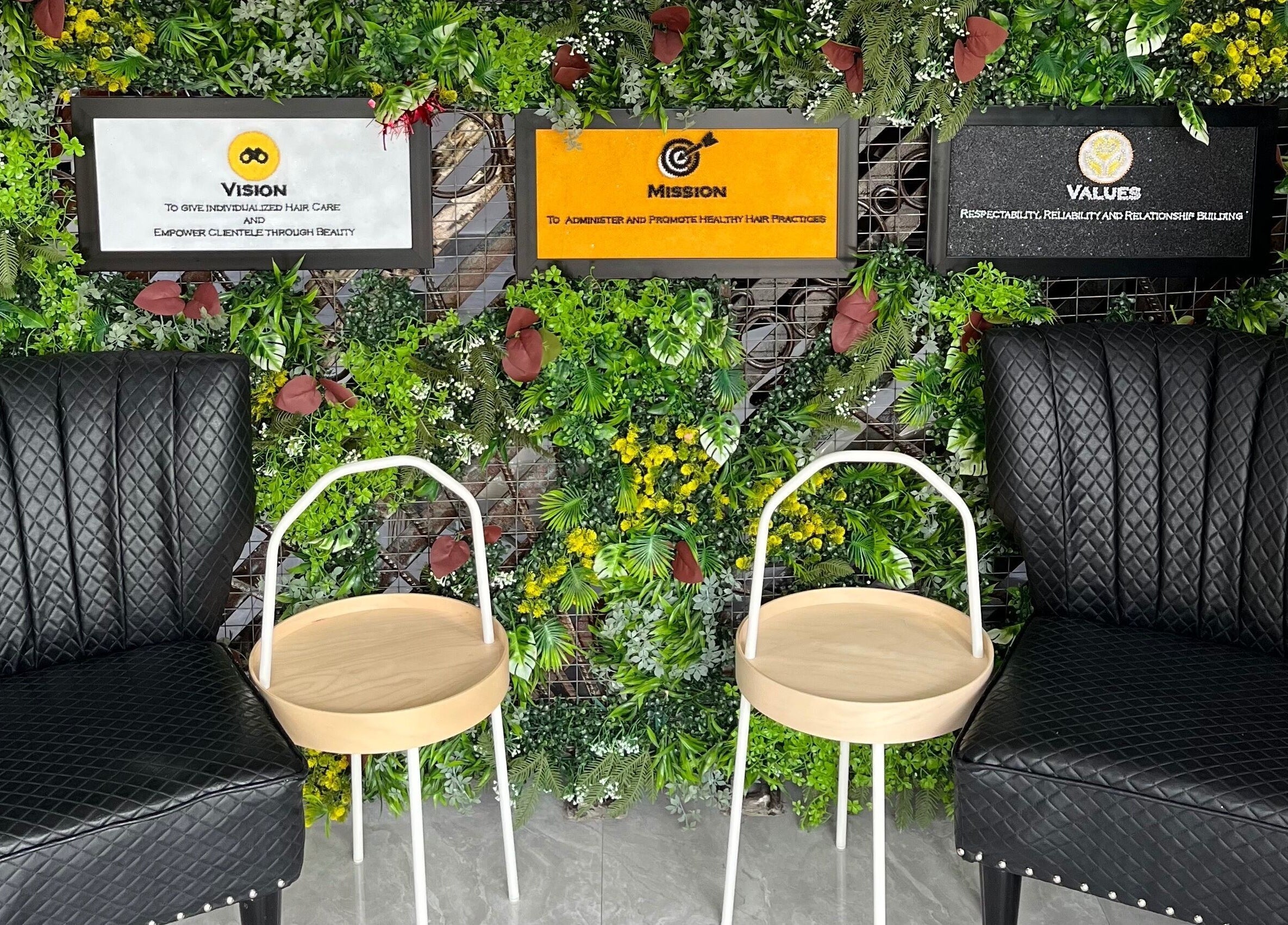 Stylish seating at Studio M, Lagos, Lagos, NG with black chairs, wooden tables, set against lush green decor.