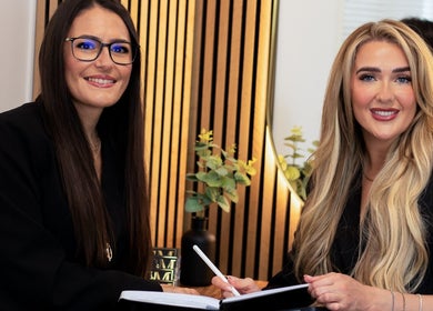 Stylists at Hair by Chloe Moore, Paisley, Scotland discuss beauty plans in a warmly lit salon.