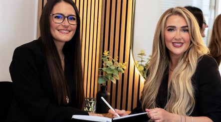 Stylists at Hair by Chloe Moore, Paisley, Scotland discuss beauty plans in a warmly lit salon.