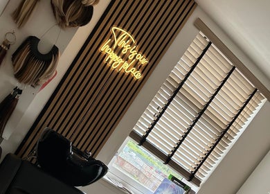 Modern salon decor at Hair by Chloe Moore, Paisley, Scotland, GB with hair extensions and neon sign.