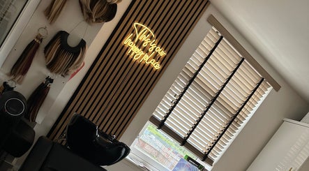 Modern salon decor at Hair by Chloe Moore, Paisley, Scotland, GB with hair extensions and neon sign.
