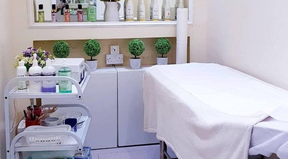 Calming treatment room at Absolute Joy Spa, London, England, GB showcasing skincare products and cozy setup.