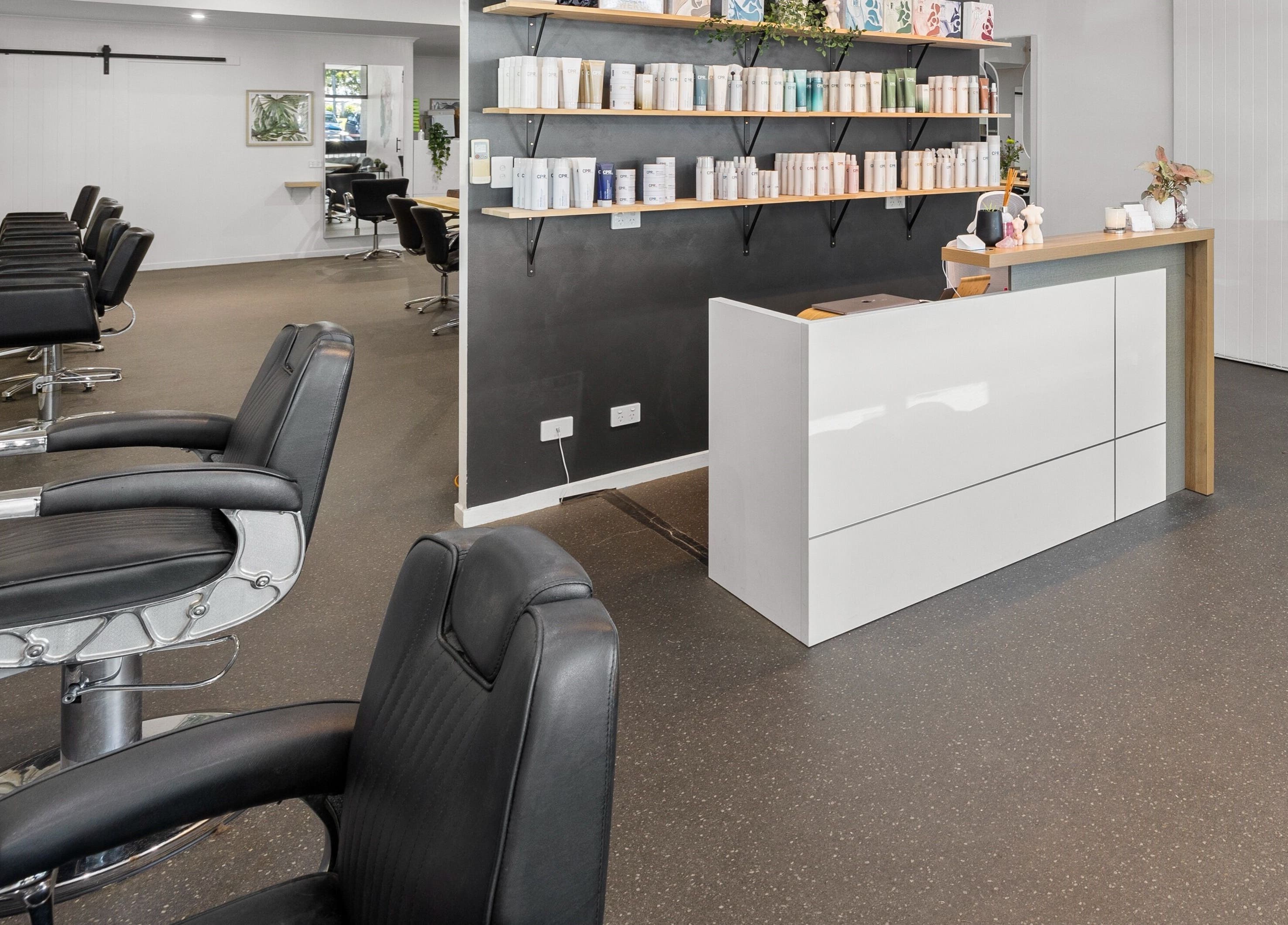 Elegant interior of Mane Studioz in Bongaree, Queensland, AU featuring modern styling chairs and product shelves.