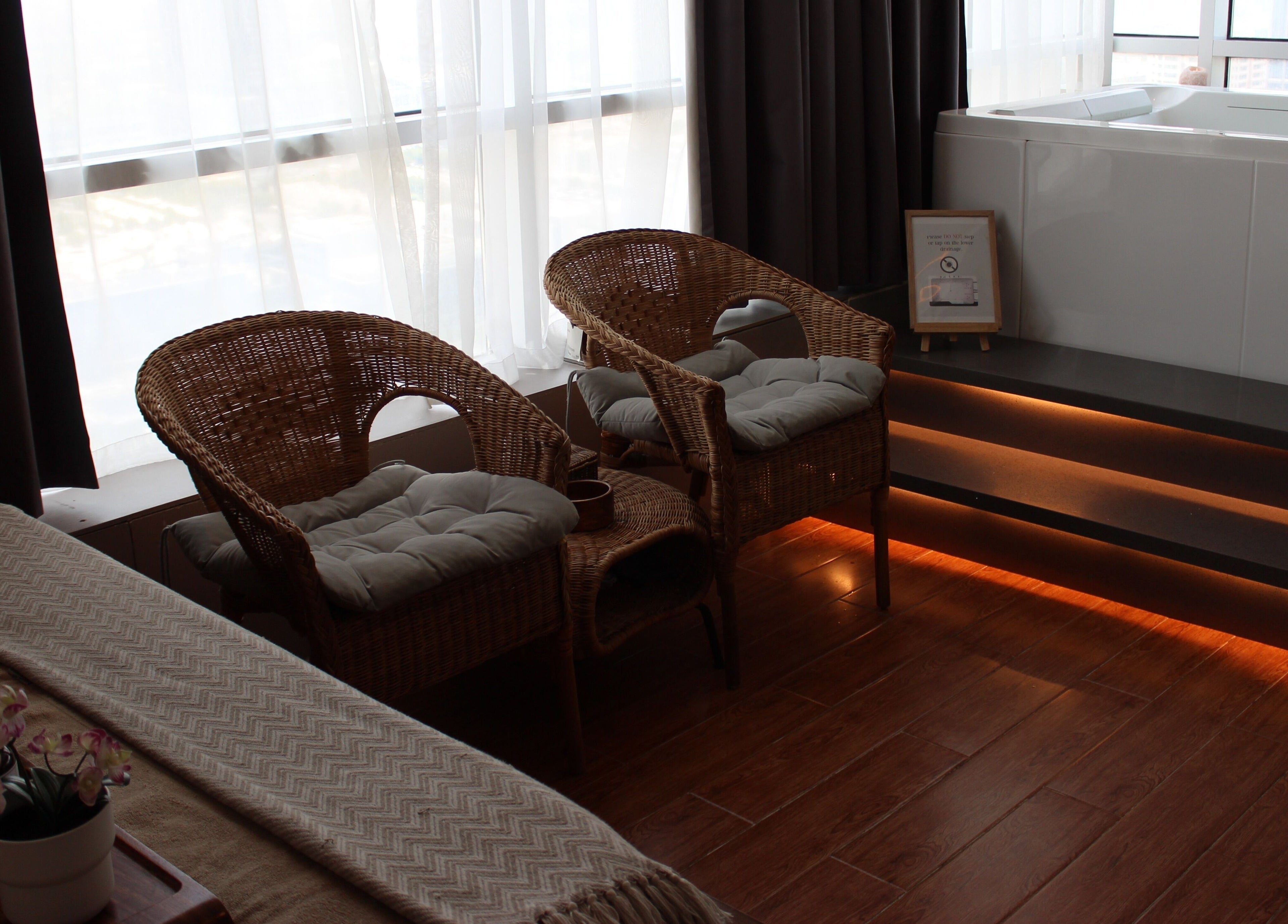 Cozy relaxation space at Zeerla Spa Media City, Dubai Media City, دبي, AE with wicker chairs and soft lighting.