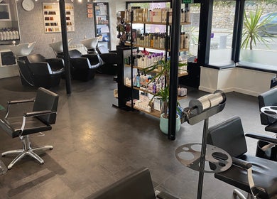 Modern interior of The Hive Hair • Beauty in St Austell, England, GB featuring sleek salon chairs and product display.