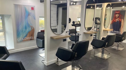 Modern salon interior at The Hive Hair • Beauty, St Austell, England, GB with stylish black chairs and mirrors.