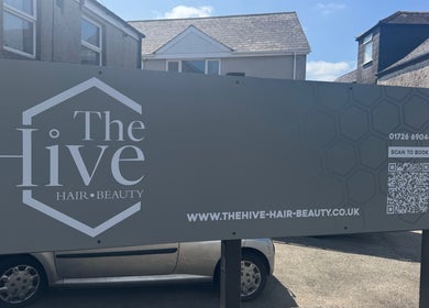 The Hive Hair • Beauty exterior sign in St Austell, England, GB, featuring booking details and website link.