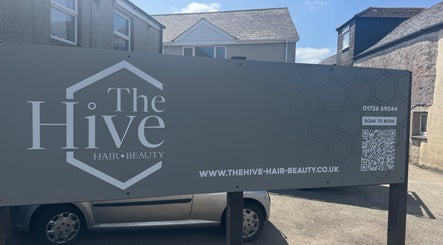 The Hive Hair • Beauty exterior sign in St Austell, England, GB, featuring booking details and website link.
