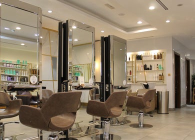 Modern salon chairs and mirrors at Legend Beauty Centre, Dubai, Dubai, AE, offering luxurious styling services.