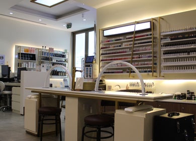 Interior view of Legend Beauty Centre, Dubai, AE showcasing chic manicure stations and elegant nail polish displays.