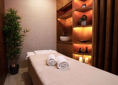 Tranquil spa room at Legend Beauty Centre, Dubai, Dubai, AE; massage table with rolled towels and warm lighting.