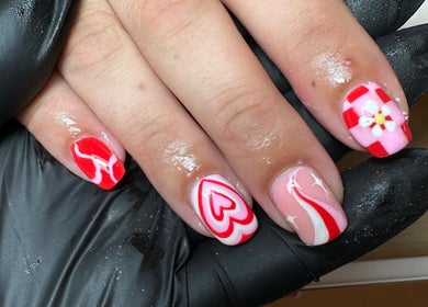 Close-up of artistic red and pink nails with heart designs at The Nail Jar, Barnstaple, England, GB.