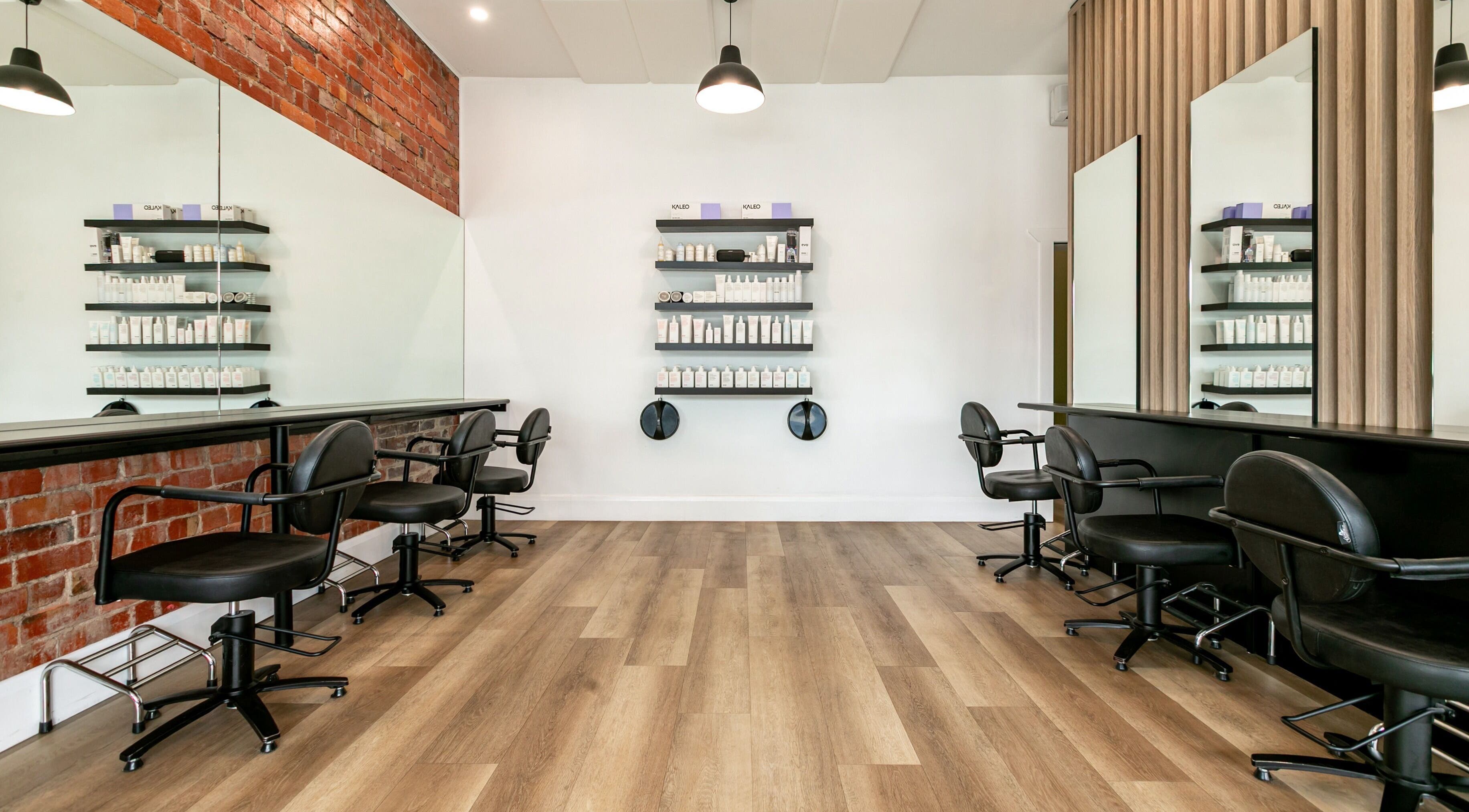 Modern salon interior at SP Salon, Melbourne, Victoria, AU with stylish chairs and product displays.