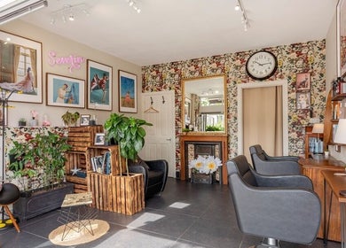 Stylish interior of Severin Hair Studio, Teddington, England, GB, showcasing elegant seating and floral decor.