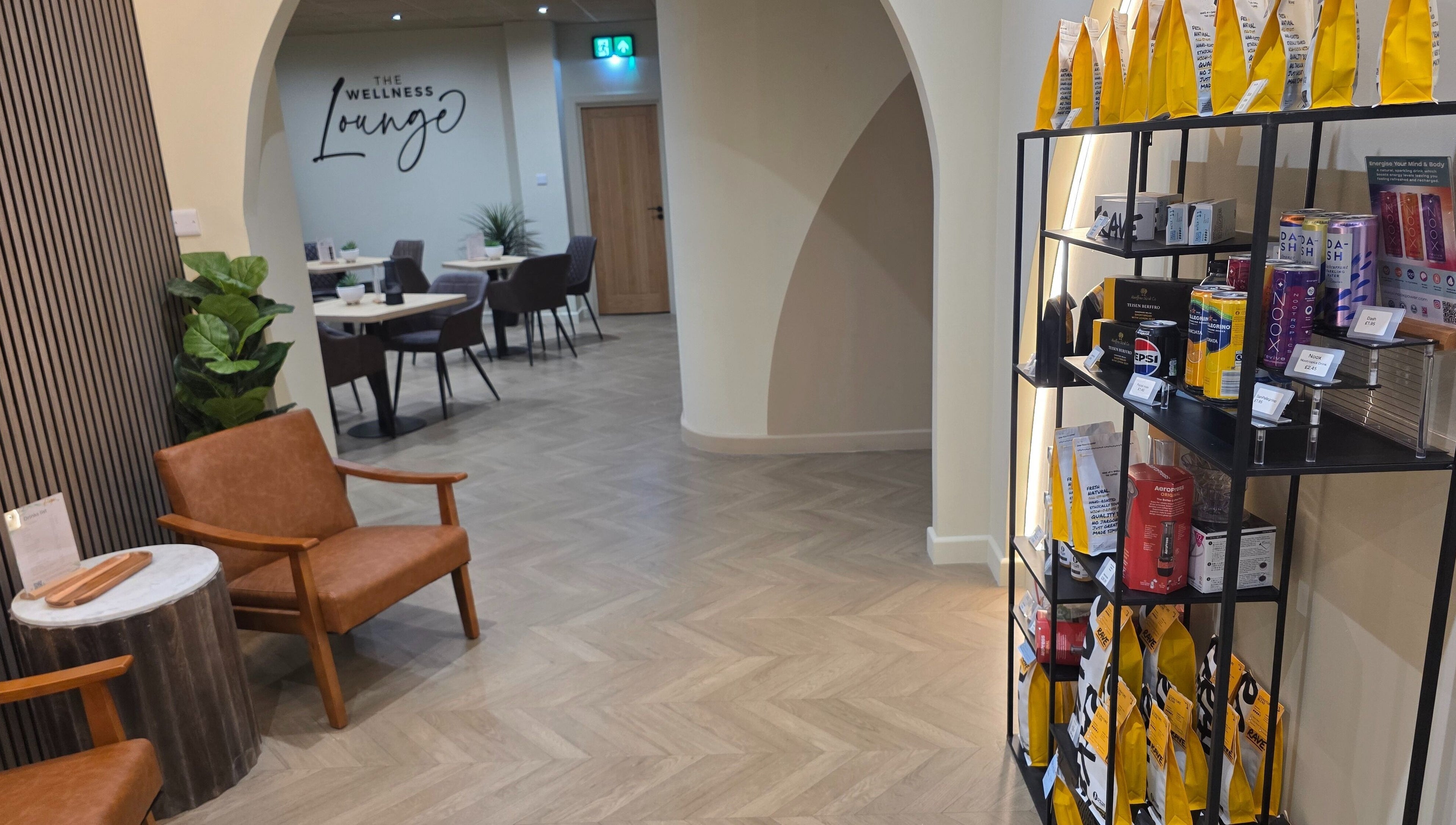 Inviting interior of The Wellness Lounge in Cardiff, Wales, GB, featuring seating and a product display area.