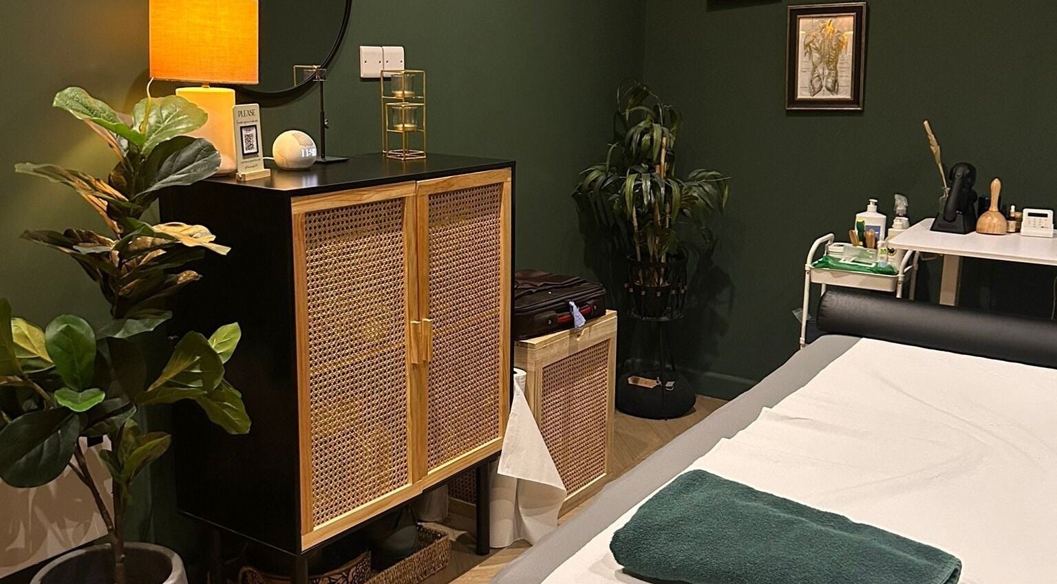 A calming therapy room at The Wellness Lounge, Cardiff, Wales, GB with a lush plant and soothing decor.
