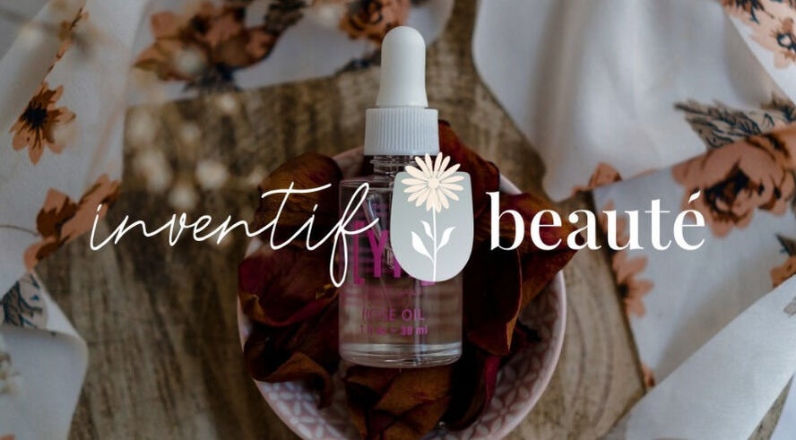 Inventif Beauté Mossel Bay features rose oil on floral fabric backdrop.