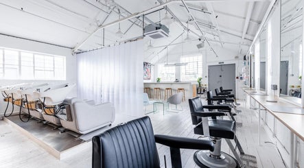 Modern interior of Salt Salon Hackney, London, England, GB, with sleek styling chairs and washing stations.