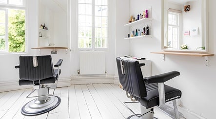 Stylish haircut chairs at SALT Salon Hackney, London, England, GB, basking in natural light.