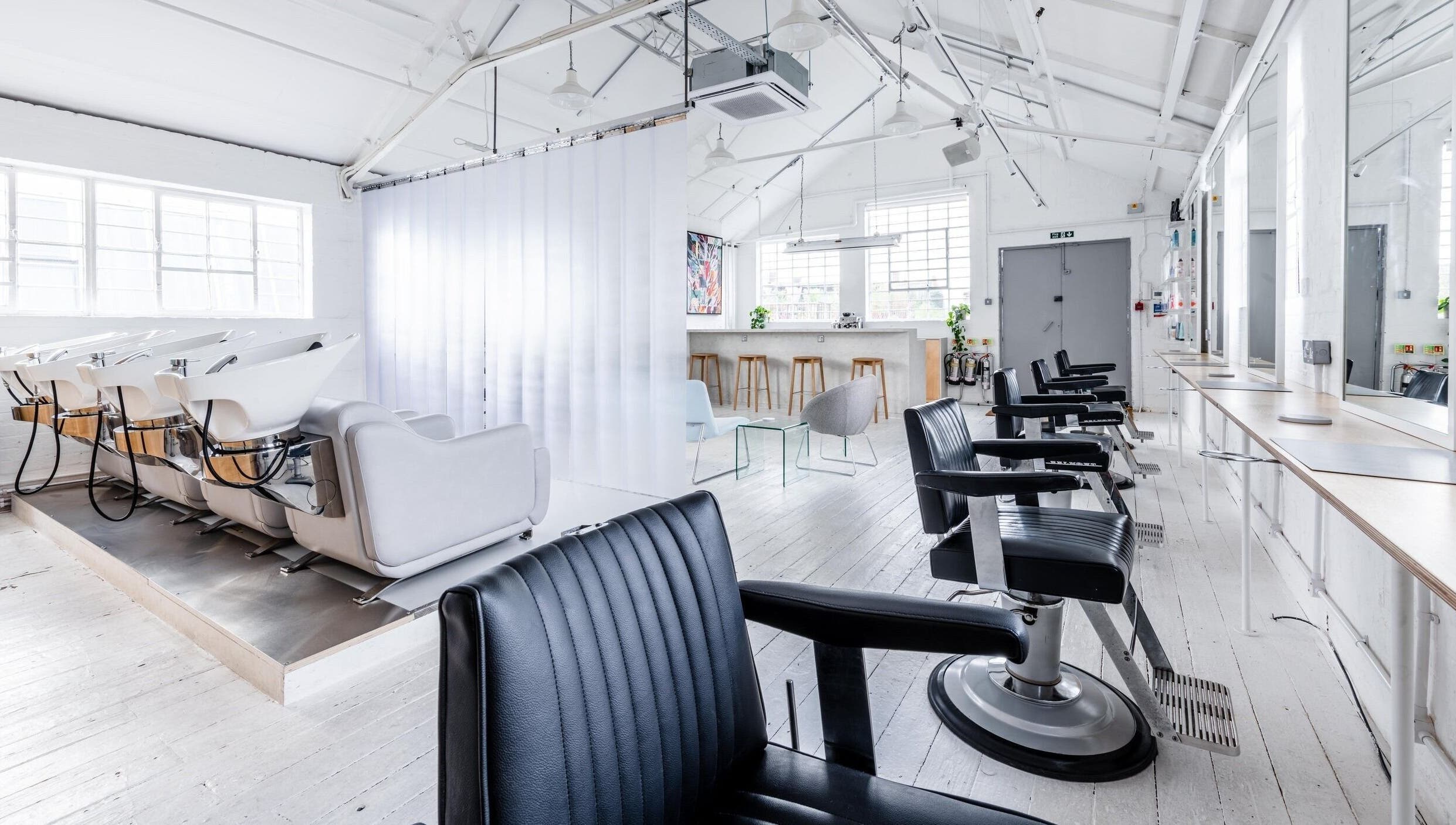 Bright, modern interior of SALT Salon Hackney in London, England, GB with sleek chairs and styling stations.