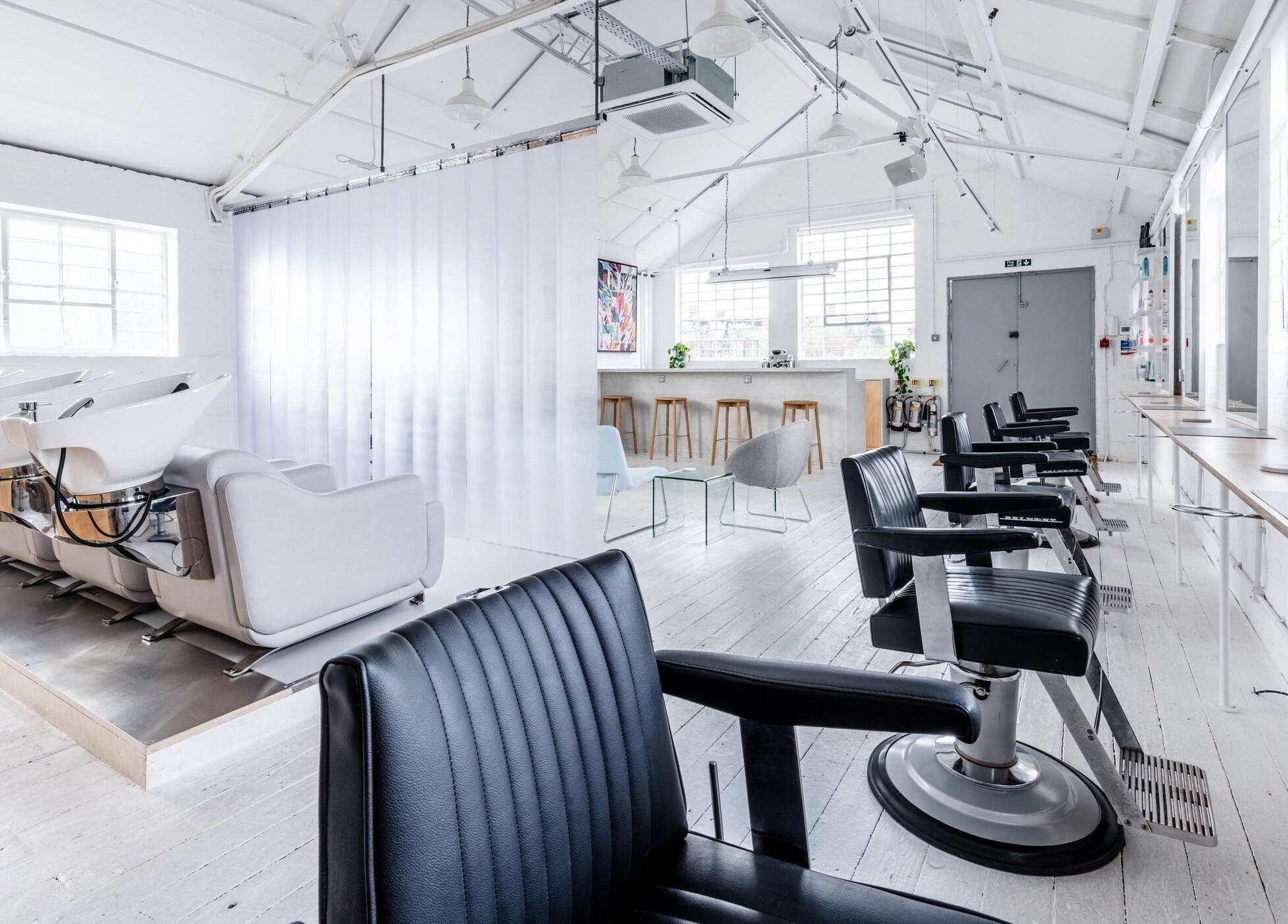 Bright, modern interior of SALT Salon Hackney in London, England, GB with sleek chairs and styling stations.