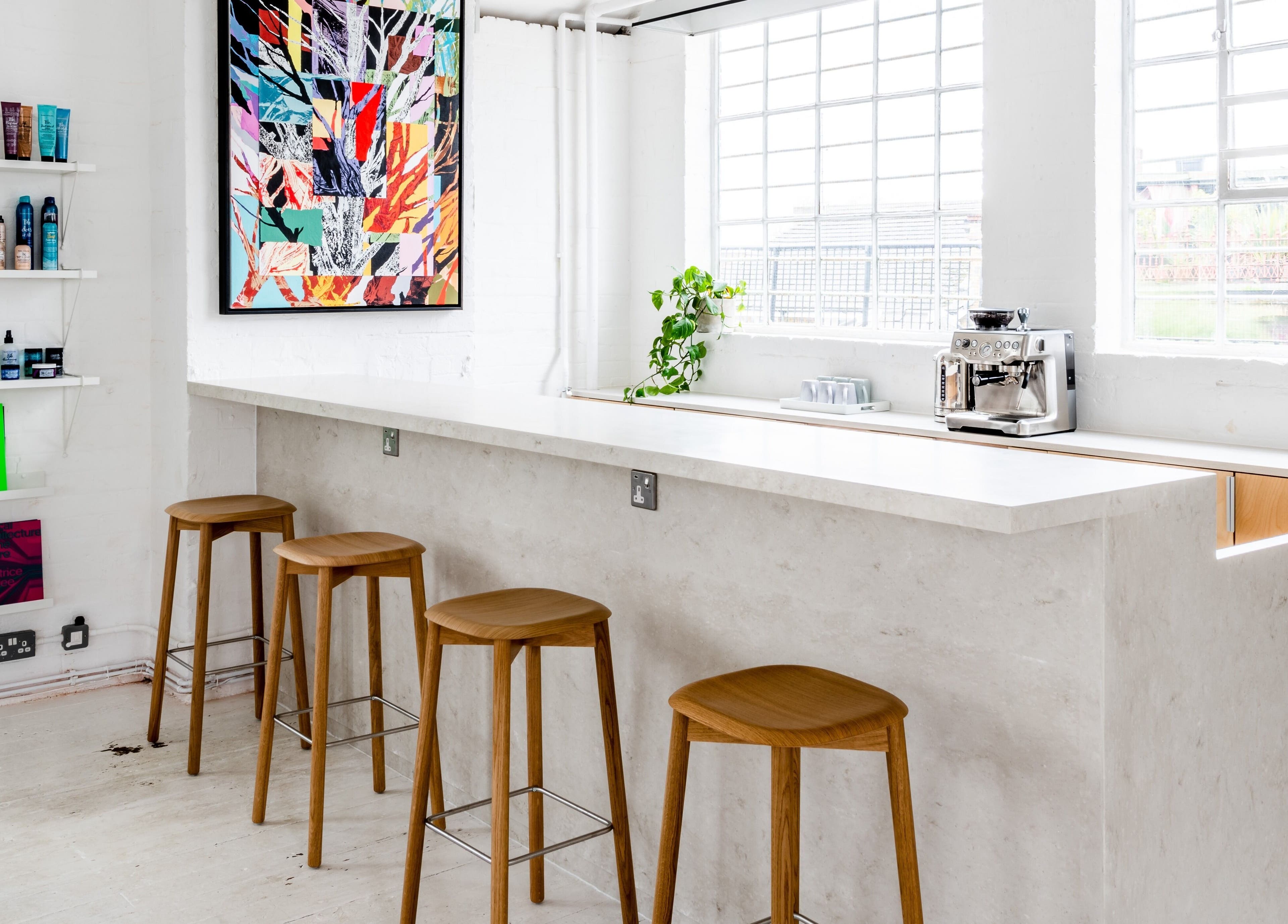 Bright interior of SALT Salon Hackney in London, England, GB featuring a minimalistic design with barstools.