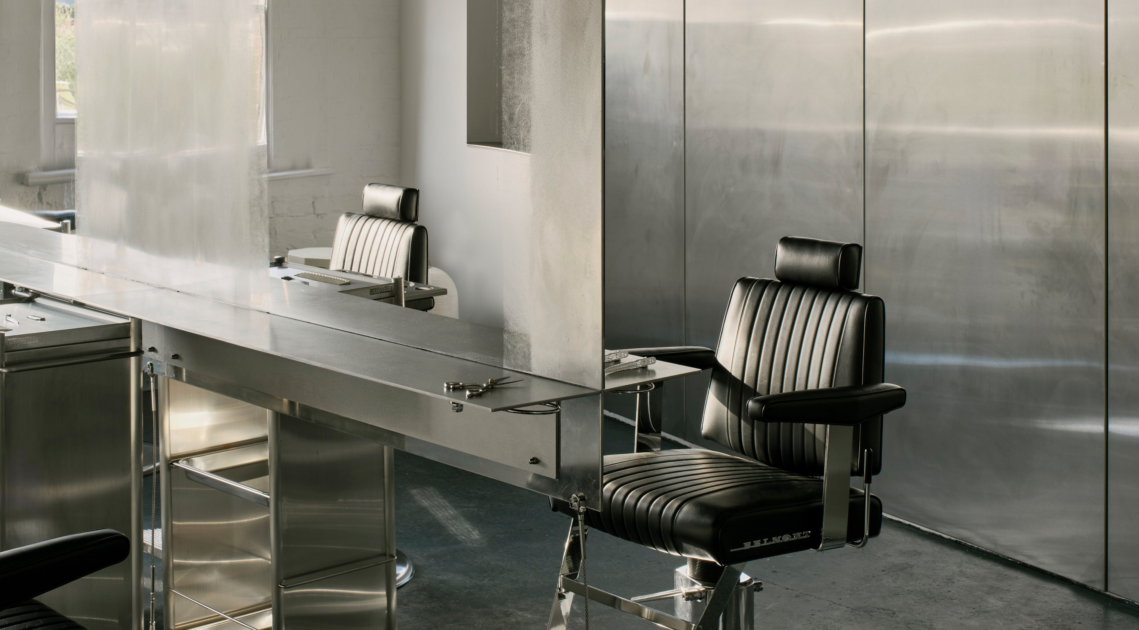 Modern salon interior at SALT Salon Borough, London, England, GB, showcasing sleek styling chairs and mirrors.