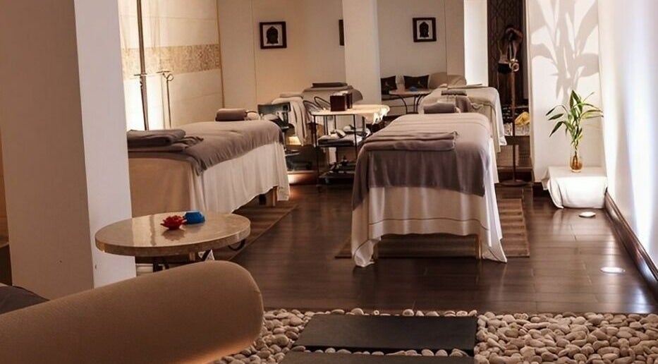 Tranquil spa room at The Residence Mauritius, Flacq District, MU, featuring massage tables and ambient lighting.