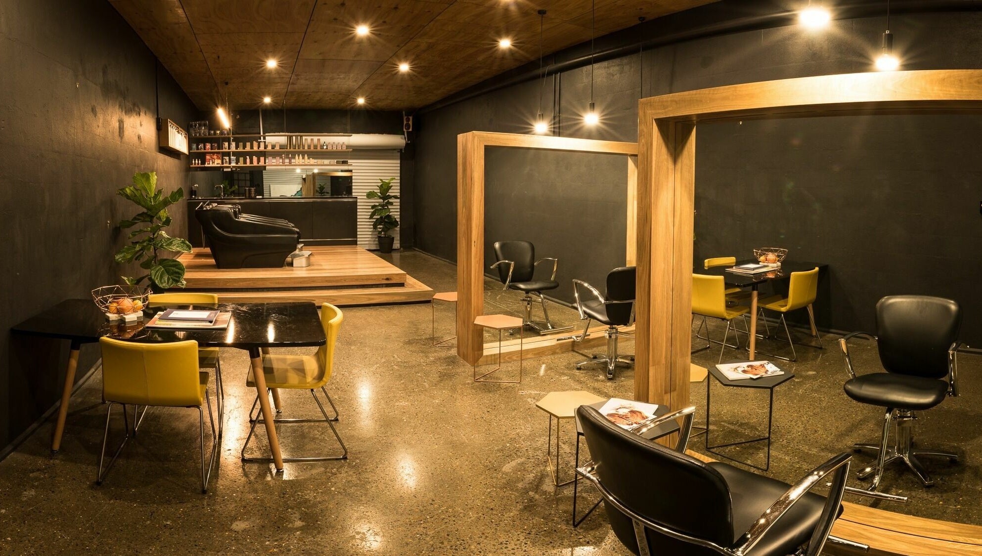 Interior of Stable Space salon in Miami, Queensland, AU with sleek black and yellow chairs, mirrors, and stylish decor.