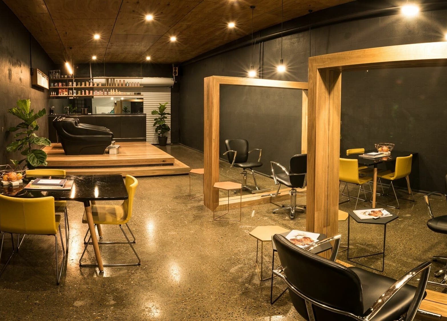 Interior of Stable Space salon in Miami, Queensland, AU with sleek black and yellow chairs, mirrors, and stylish decor.