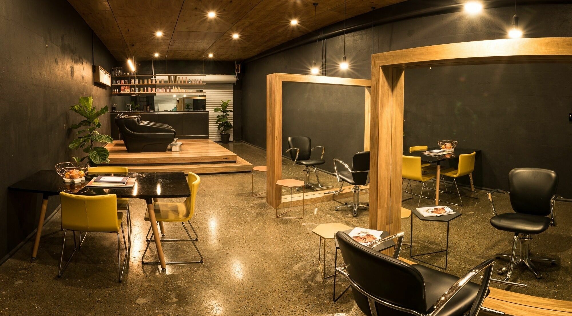 Interior of Stable Space salon in Miami, Queensland, AU with sleek black and yellow chairs, mirrors, and stylish decor.