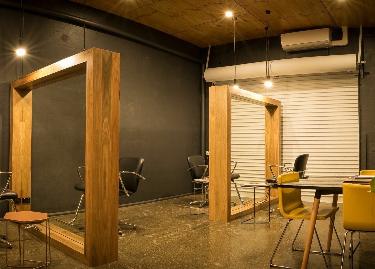 Stylish salon space at Stable Space, Miami, Queensland, AU with modern wood frames and sleek chairs.