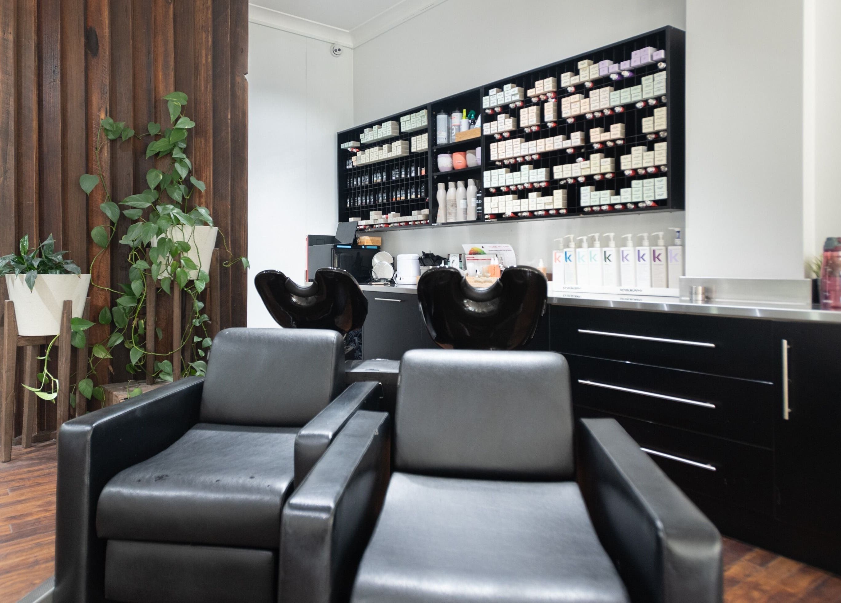 Modern hair salon interior at Moscato Hair, West Melbourne, VIC, AU with sleek chairs and product shelves.