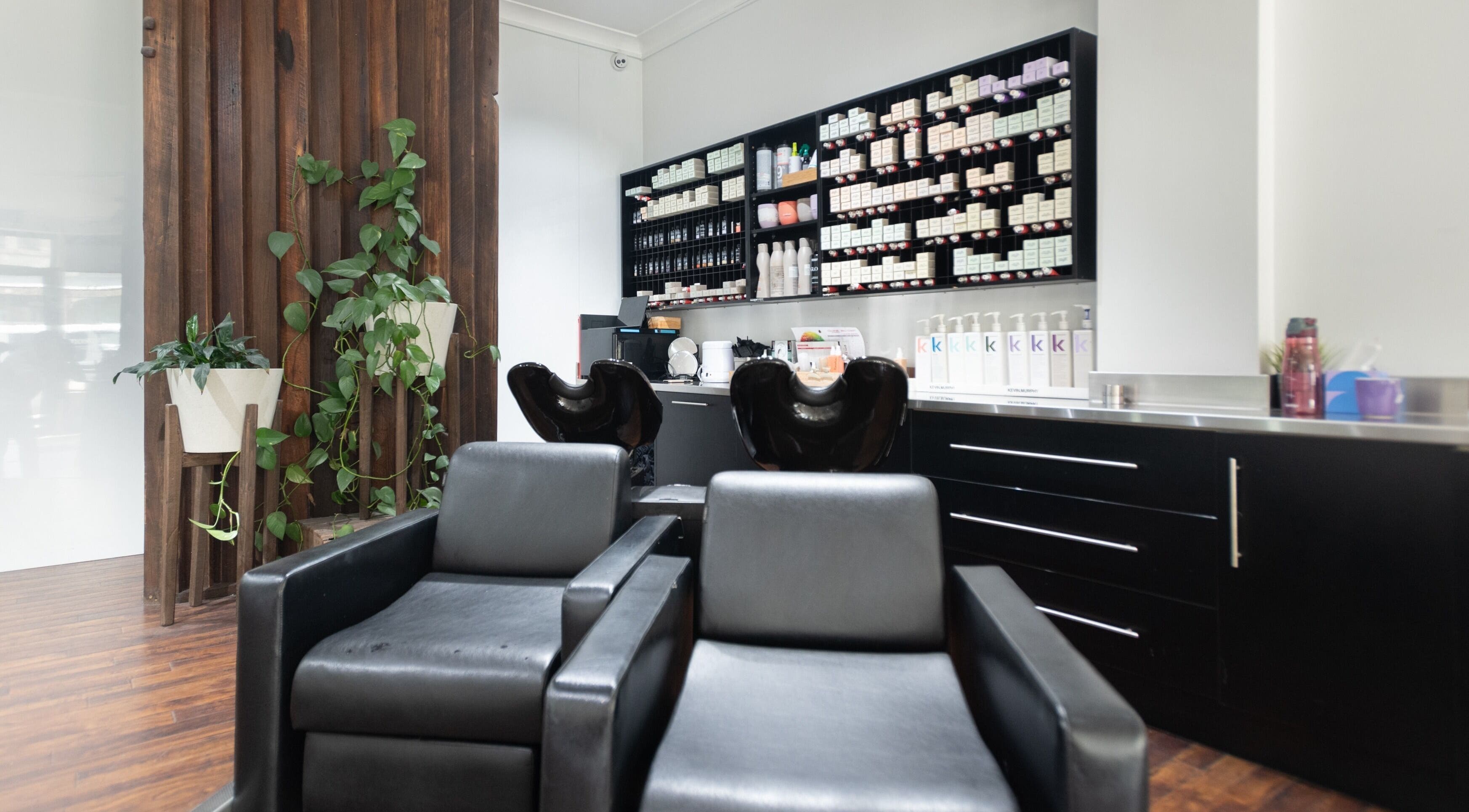 Modern hair salon interior at Moscato Hair, West Melbourne, VIC, AU with sleek chairs and product shelves.