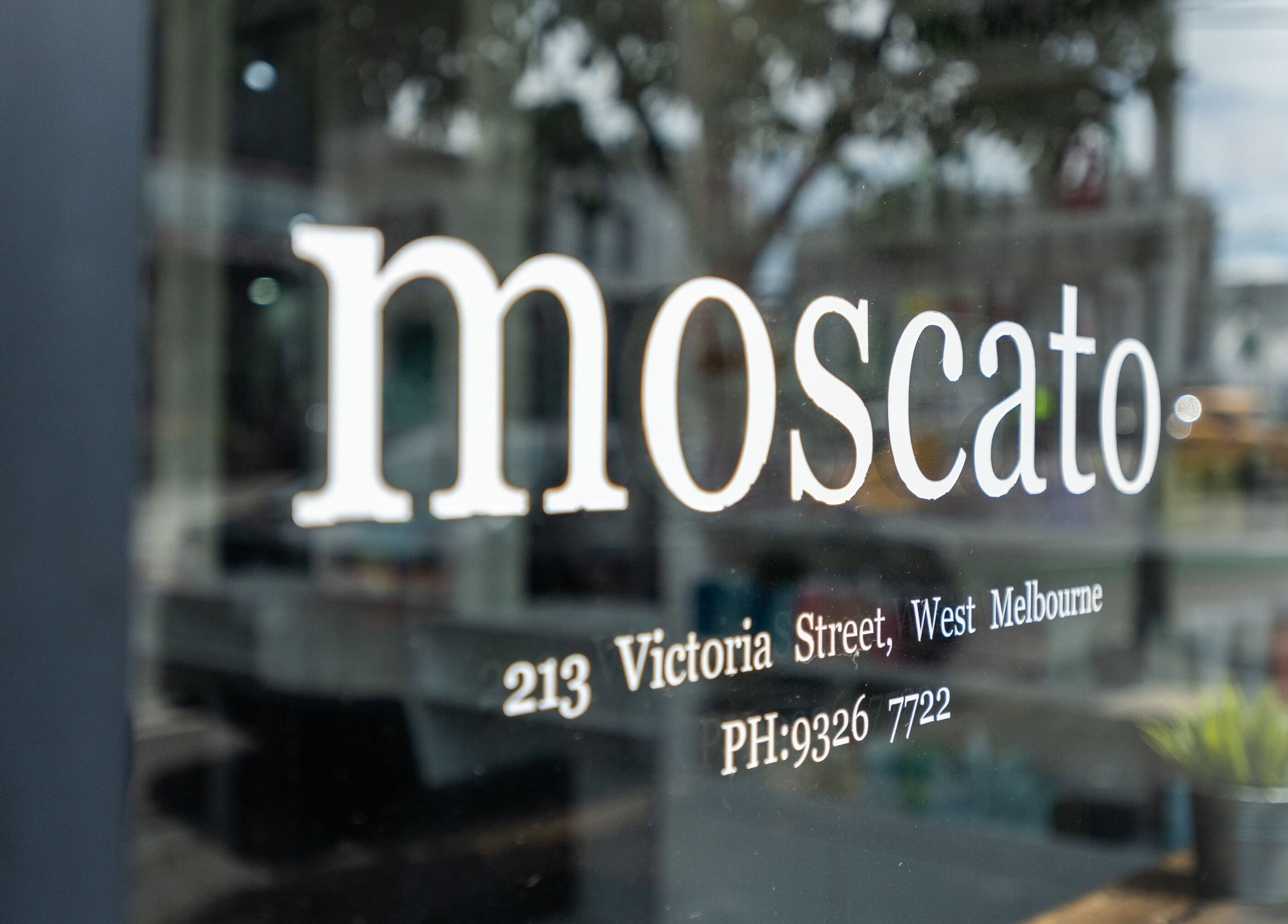 Signage of Moscato Hair at 213 Victoria Street, West Melbourne, VIC, AU on a modern glass window.
