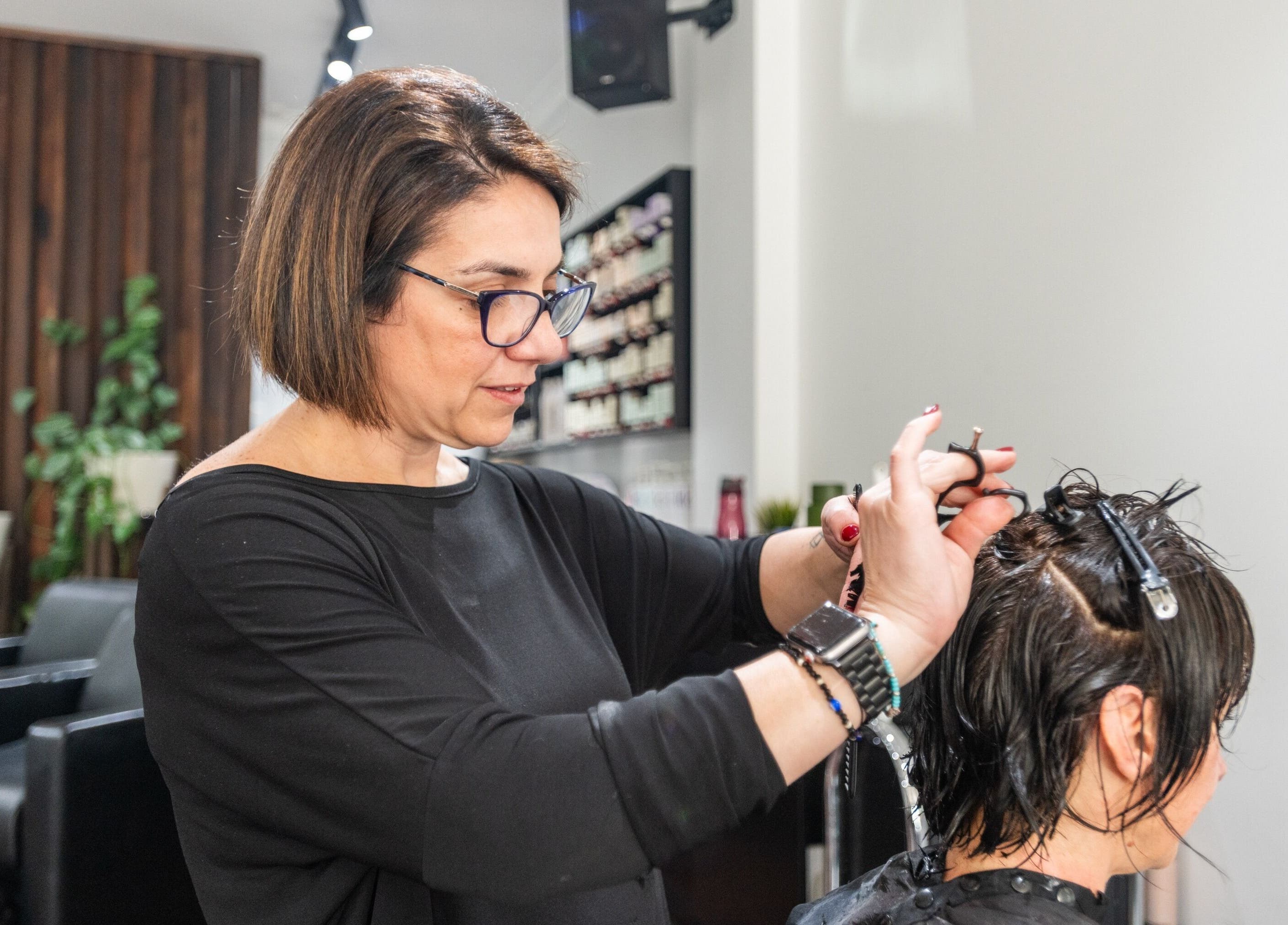 Stylist cutting hair at Moscato Hair, West Melbourne, VIC, AU. Professional salon service captured in action.