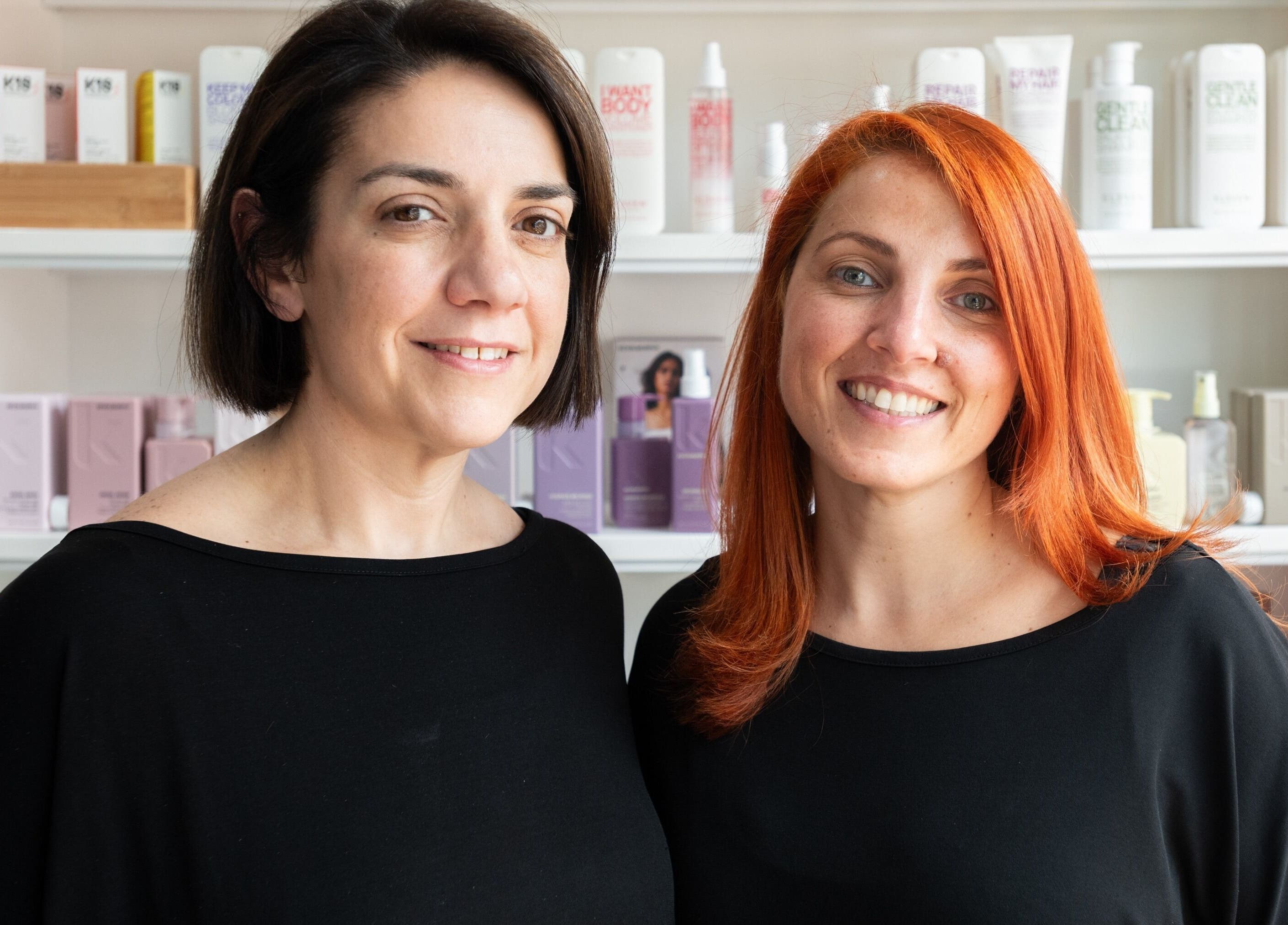 Two stylists at Moscato Hair, West Melbourne, VIC, AU, smiling in front of salon products.