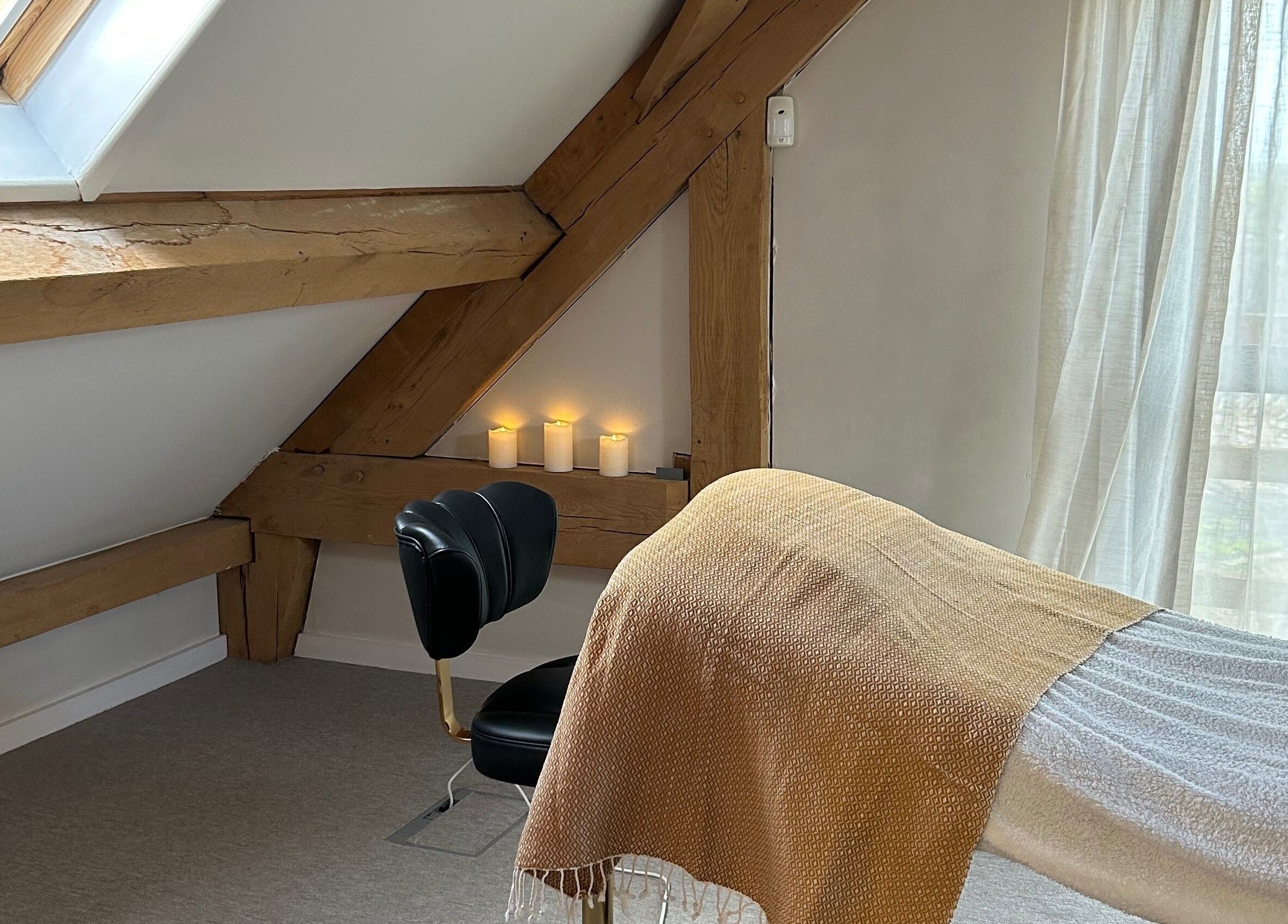 Relaxing treatment room at Rewild Reflexology - Luxe Barn Tickenham, Tickenham, England, GB with candles and cozy decor.