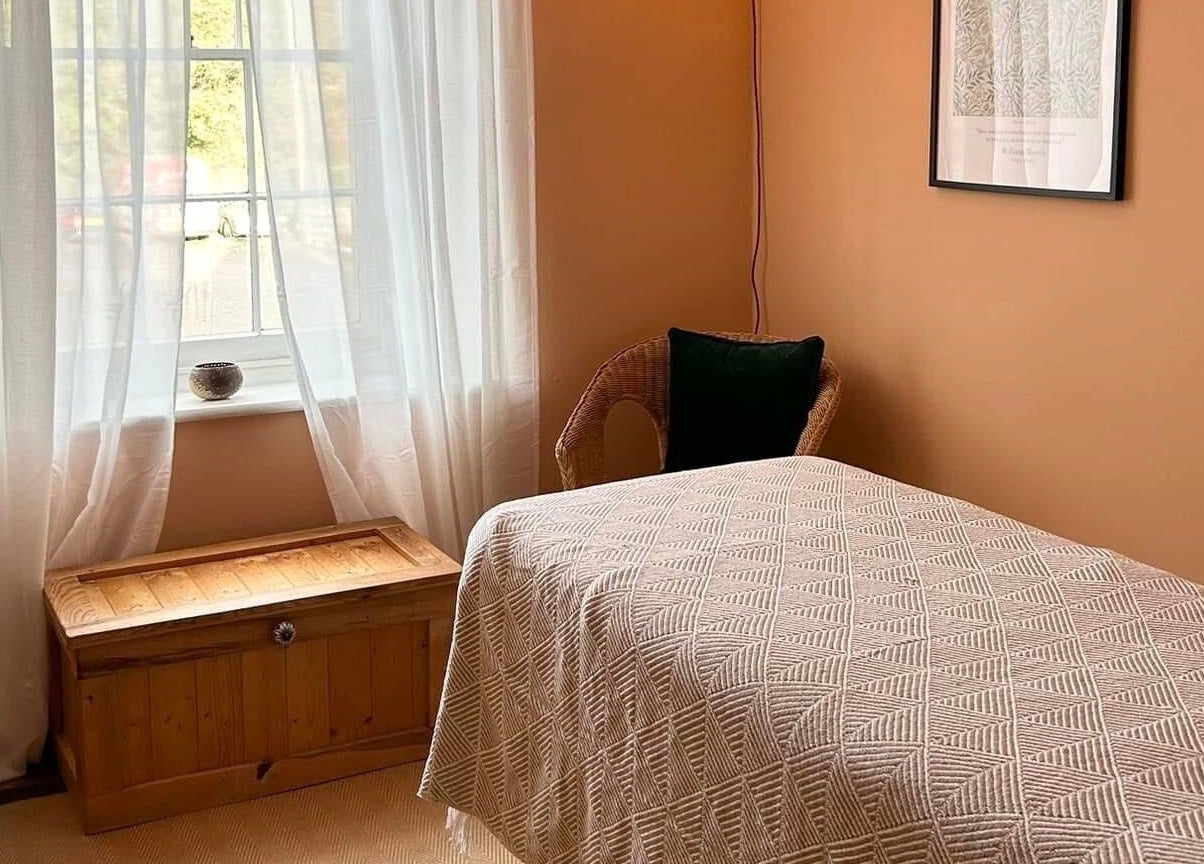 Relaxing room at Rewild Reflexology - Frome, featuring a cozy bed and soft lighting in Frome, England, GB.