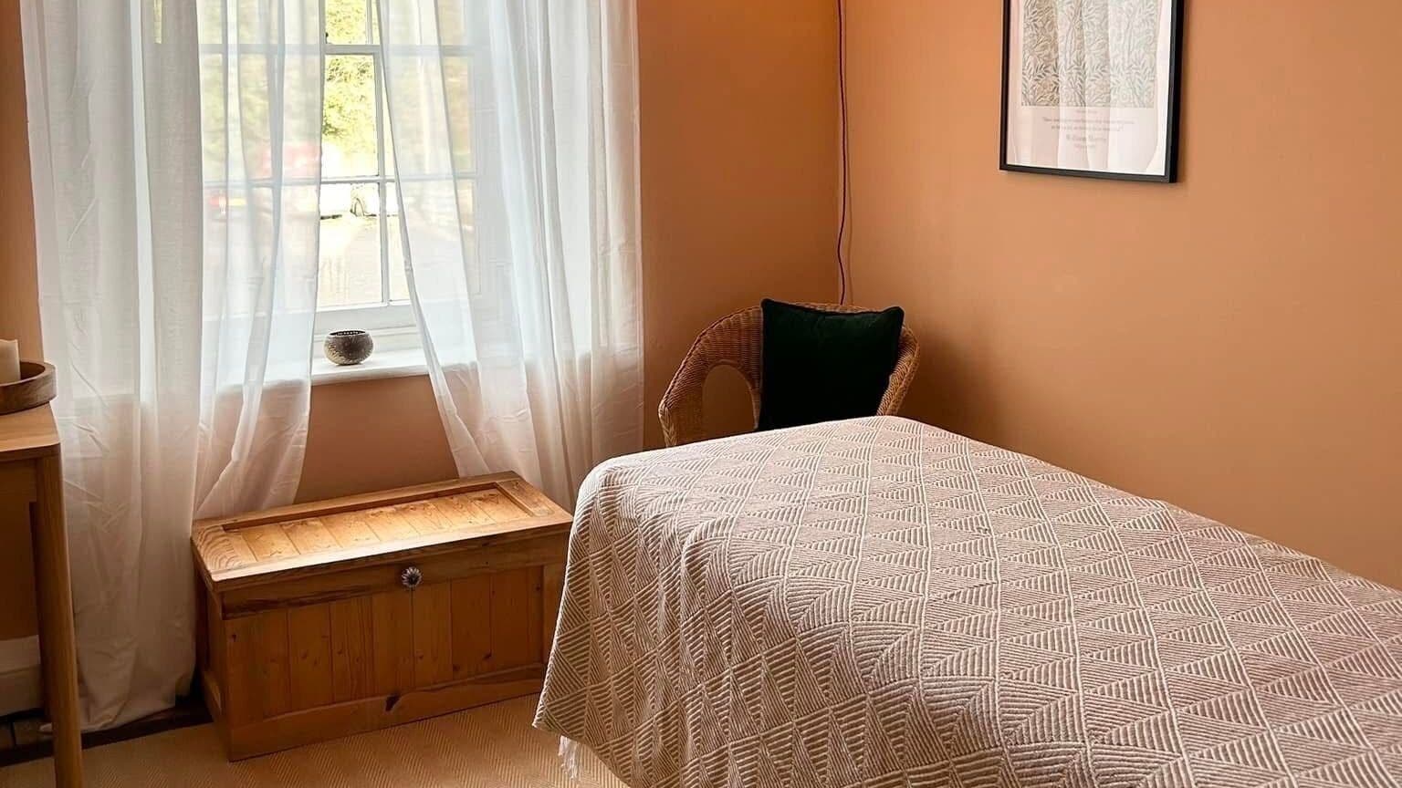 Relaxing room at Rewild Reflexology - Frome, featuring a cozy bed and soft lighting in Frome, England, GB.