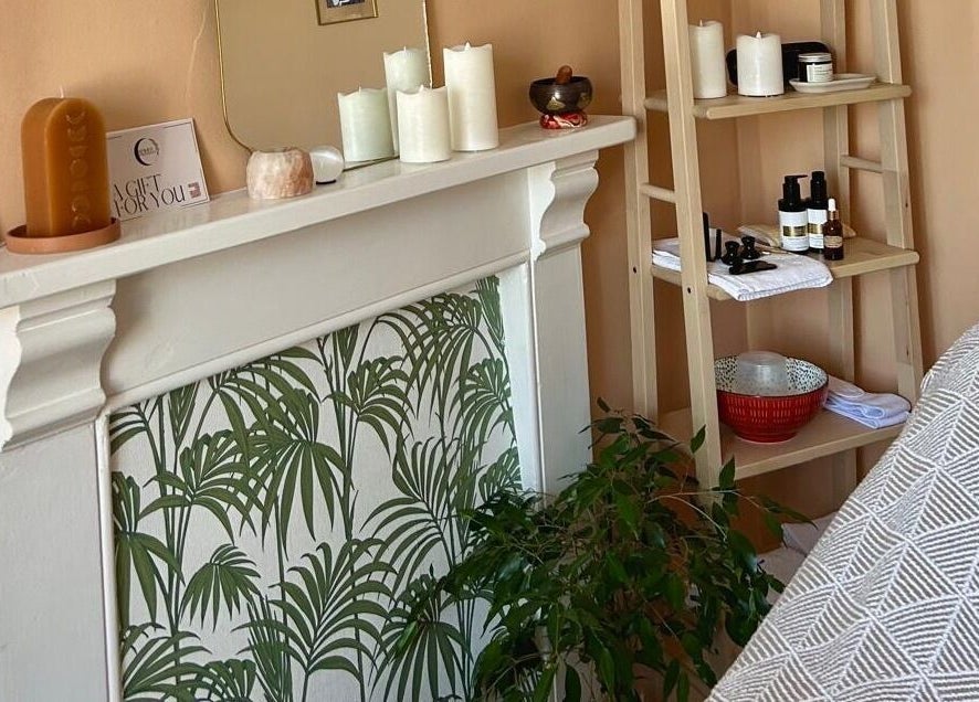Cozy therapy room at Rewild Reflexology - Frome, featuring warm decor, candles, and wellness products. Frome, England, GB.