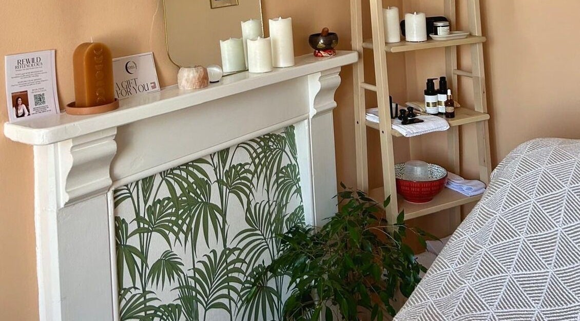 Cozy therapy room at Rewild Reflexology - Frome, featuring warm decor, candles, and wellness products. Frome, England, GB.