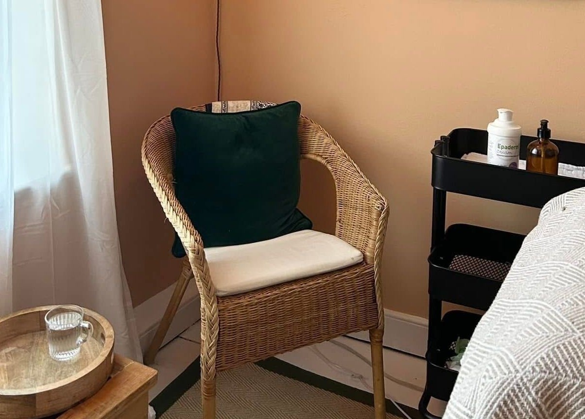 Cozy corner of Rewild Reflexology - Frome in Frome, England, GB with wicker chair and relaxing decor.