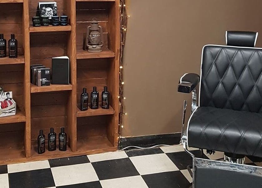 Prestige Barbers in Bebington, England, GB features a sleek black barber chair and product display.