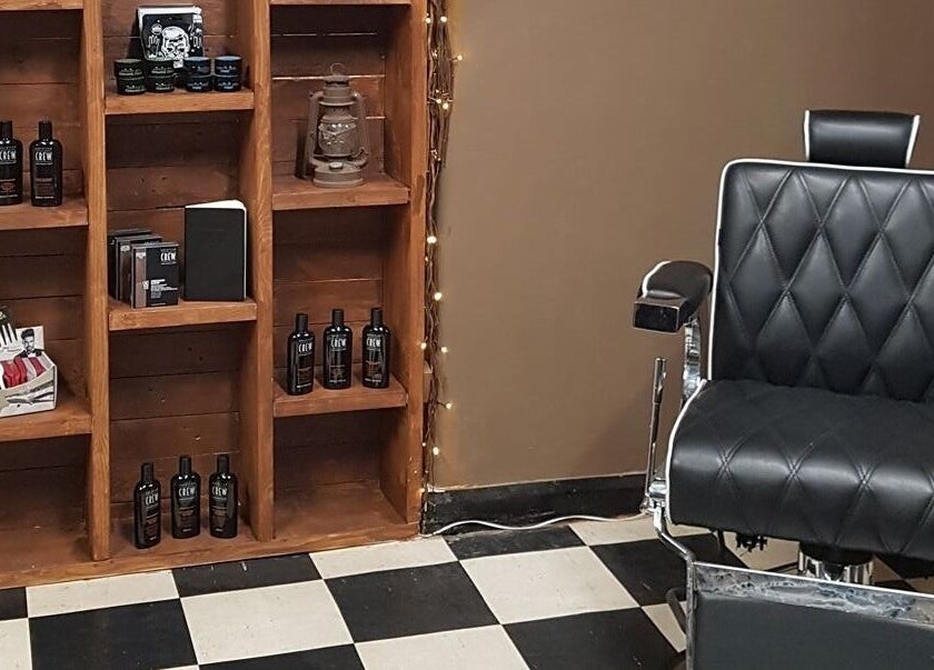 Prestige Barbers in Bebington, England, GB features a sleek black barber chair and product display.