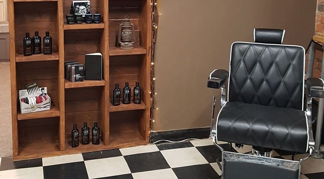 Prestige Barbers in Bebington, England, GB features a sleek black barber chair and product display.
